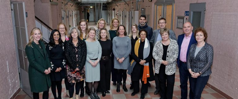 Stuurgroepleden en leden projectgroep City Deal Zorg voor Veiligheid in de Stad staand in de voormalige Koepelgevangenis tijdens de slotbijeenkomst in Breda.