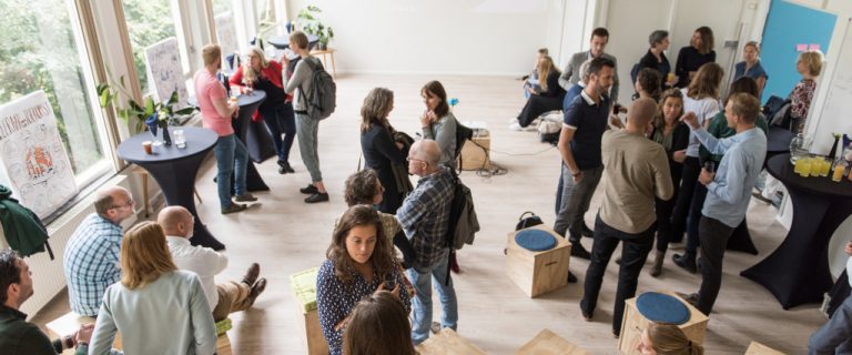 We zien van bovenaf vele deelnemers aan het Leiden Education Fieldlab met elkaar in gesprek tijdens een informeel moment