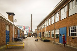 Fabrieksterrein van voormalige Prodentfabriek in Amersfoort, vrouw laat hondje uit